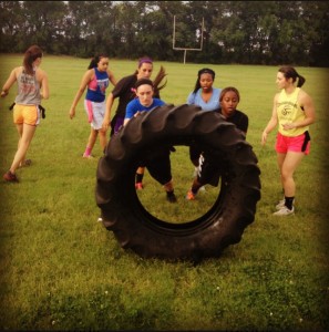 Members of the women's basketball team compete in a tire flipping contest.